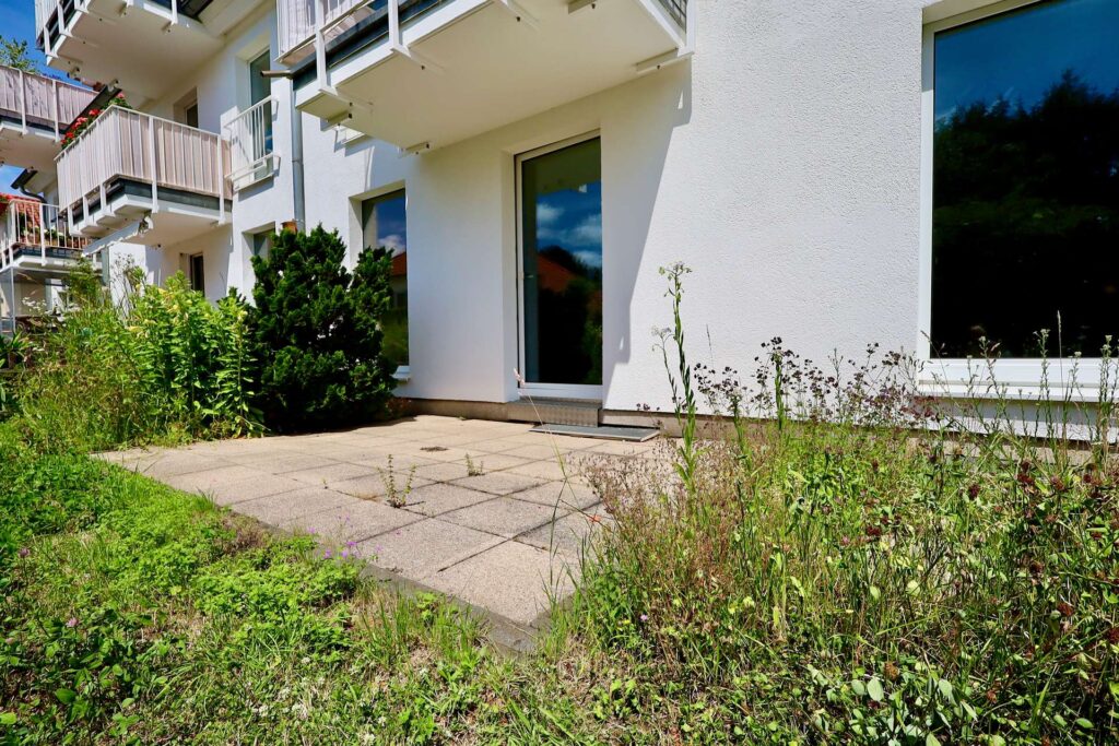 Sonnige Terrasse, dahinter der Wohn-/Essbereich.