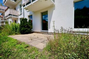 Sonnige Terrasse, dahinter der Wohn-/Essbereich.